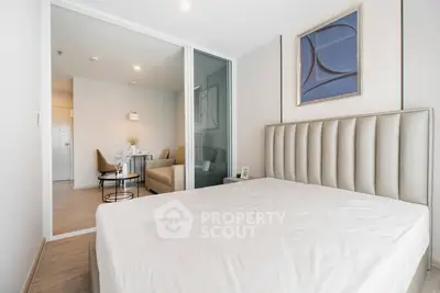 Modern bedroom with elegant decor and adjacent dining area in a stylish apartment.