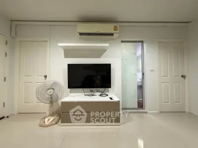 Modern living room with sleek TV setup and air conditioning, perfect for comfortable living.