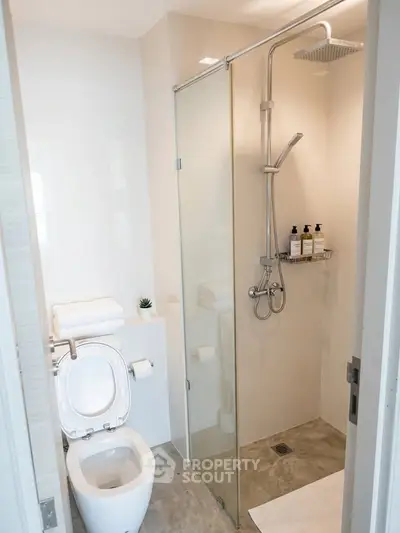 Modern bathroom with glass shower and sleek fixtures in a contemporary apartment.