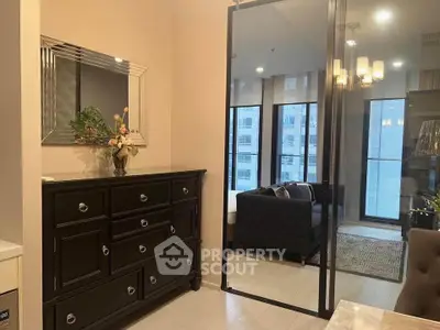 Modern apartment interior with elegant furniture and large windows offering city views.