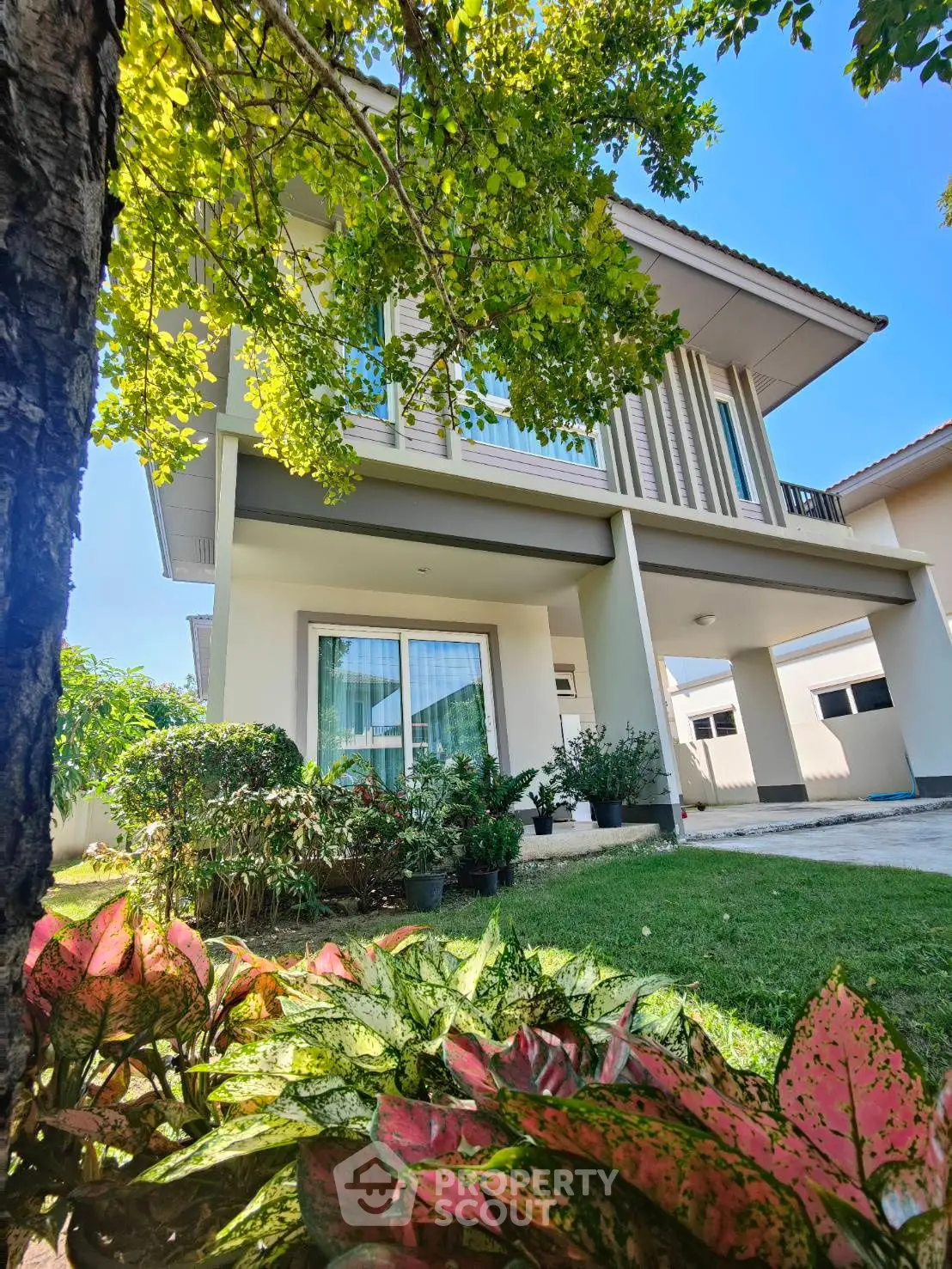 Charming two-story house with lush garden and modern design, perfect for family living.