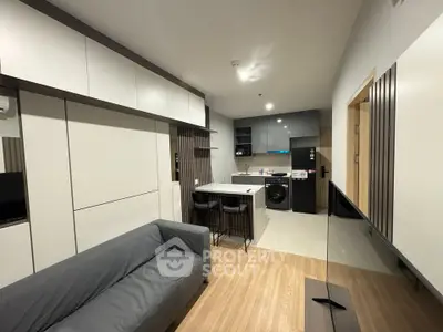 Modern open-layout living room with sleek kitchen and cozy seating area