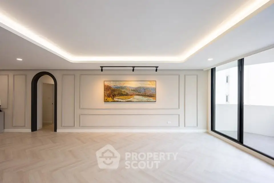 Spacious modern living room with elegant lighting and large balcony access.