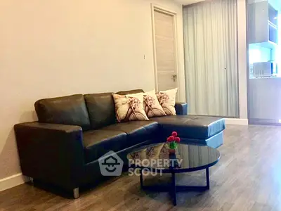 Modern living room with sleek black sofa and stylish decor in a contemporary apartment.