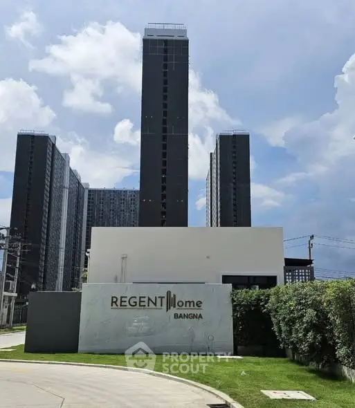 Modern high-rise building exterior with clear blue sky at Regent Home Bangna.