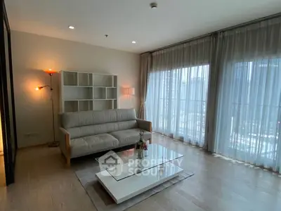 Spacious living room with modern decor and large windows offering city views.