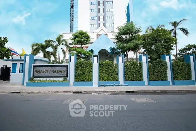 Modern building exterior with lush greenery and clear blue sky