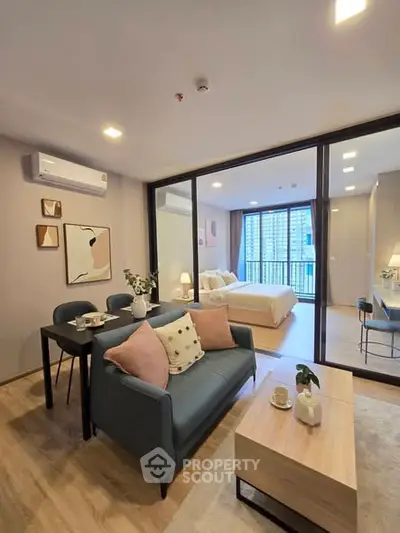 Modern open-plan living room with stylish decor and large windows in a contemporary apartment.
