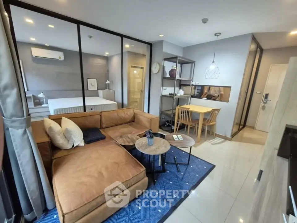 Modern open-plan living room with cozy brown sofa and stylish dining area in a contemporary apartment.