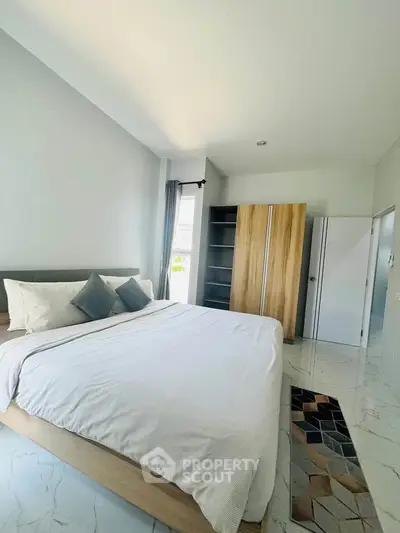 Spacious bedroom with modern decor and ample natural light