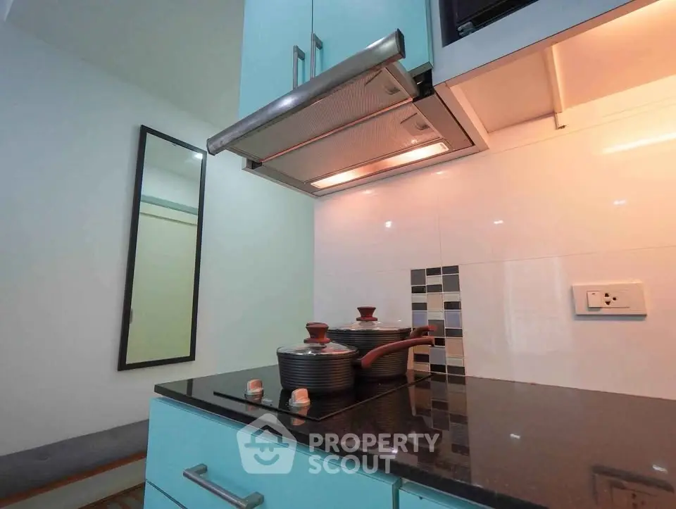 Modern kitchen with sleek cabinetry and built-in stove, perfect for culinary enthusiasts.