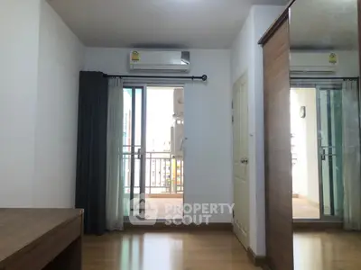 Spacious bedroom with balcony access and modern wooden flooring