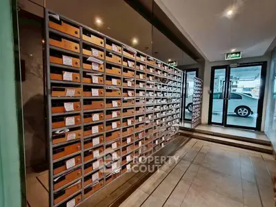 Modern apartment building entrance with mailboxes and secure parking access.