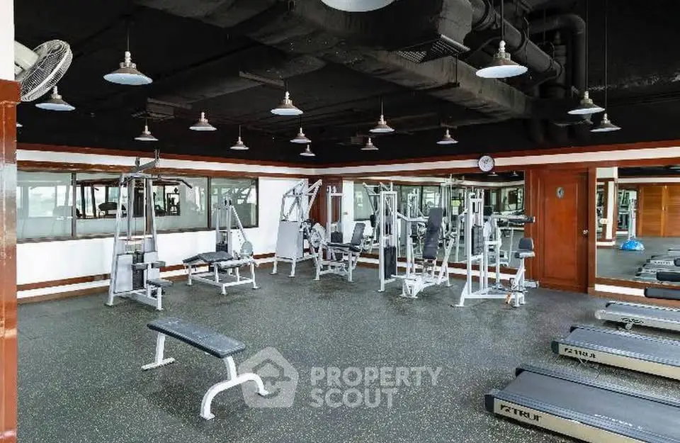 Spacious modern gym with state-of-the-art fitness equipment and ample natural light.