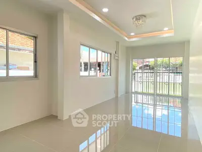 Spacious modern living room with large windows and glossy tiled floor