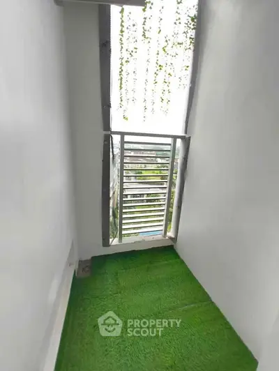 Charming small balcony with artificial grass and scenic view, perfect for relaxation.