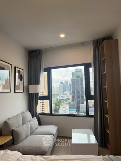 Modern bedroom with city view, featuring a cozy sofa and stylish decor, perfect for urban living.