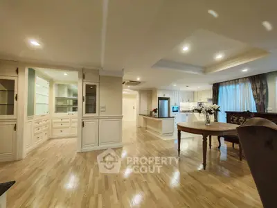 Spacious open-plan living and dining area with elegant wooden flooring and modern lighting.