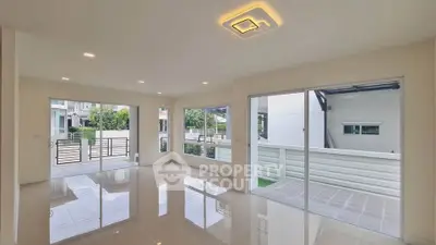 Spacious modern living room with large windows and glossy tile flooring