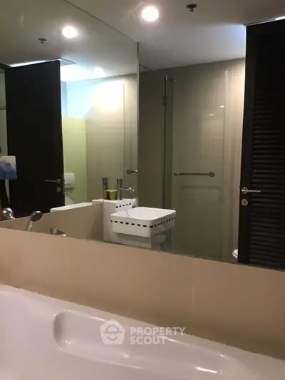 Modern bathroom with sleek design, featuring a bathtub and stylish fixtures.