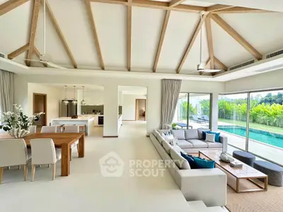 Luxurious open-plan living room with pool view and modern kitchen