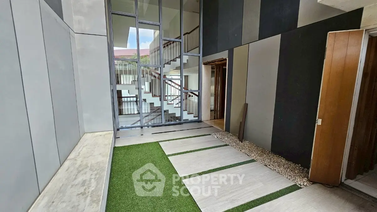 Modern building entrance with sleek design and artificial grass