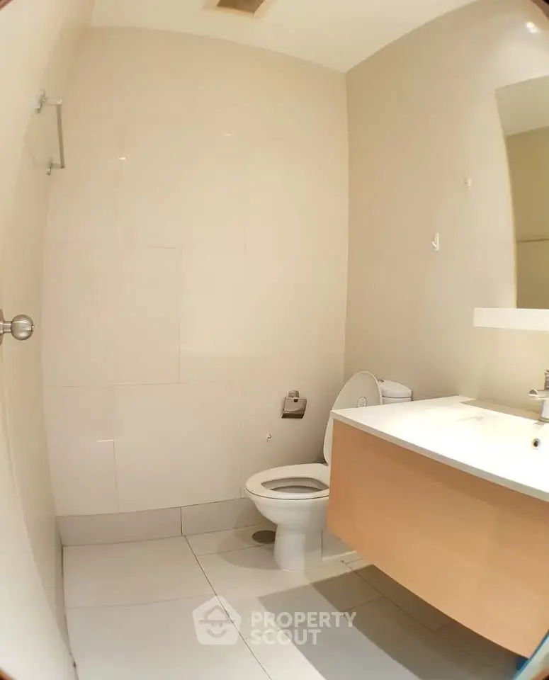 Modern bathroom with sleek fixtures and minimalist design, featuring a wall-mounted vanity and neutral tiles.