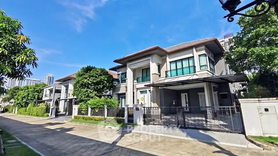 Luxurious modern homes with lush greenery and clear blue skies in a serene neighborhood.