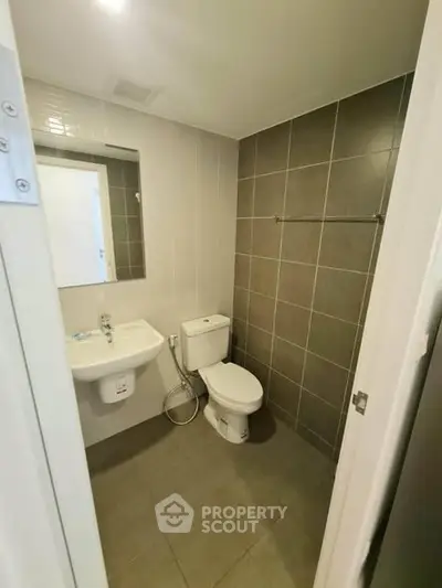 Modern bathroom with sleek fixtures and neutral tiles, perfect for a contemporary home.