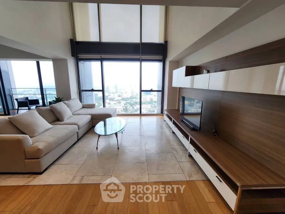 Luxurious living room with panoramic city view and modern furnishings.