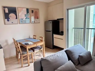Modern living room with dining area and sleek kitchen in open layout apartment.