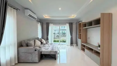 Spacious modern living room with sleek furniture and large windows offering natural light.