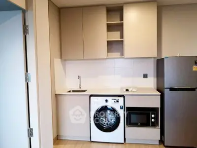 Modern compact kitchen with integrated appliances and sleek cabinetry
