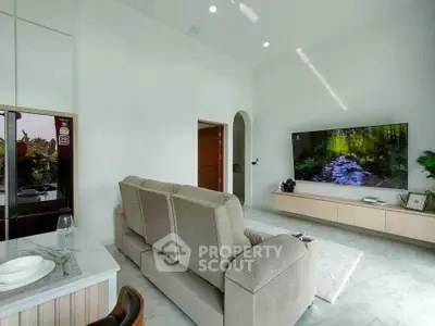 Modern living room with sleek furniture and large TV, perfect for relaxation and entertainment.