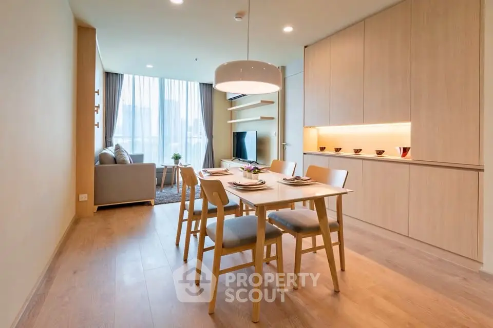 Modern open-plan living and dining area with stylish wooden furniture and natural light.