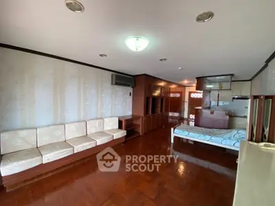 Spacious living area with wooden flooring and cozy furniture in an open layout.