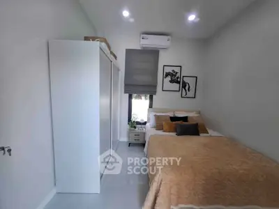 Cozy bedroom with modern decor, featuring a comfortable bed, stylish artwork, and ample storage space.