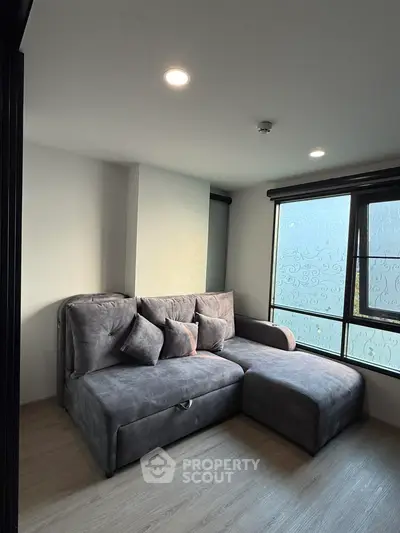 Cozy living room with modern gray sofa and large windows