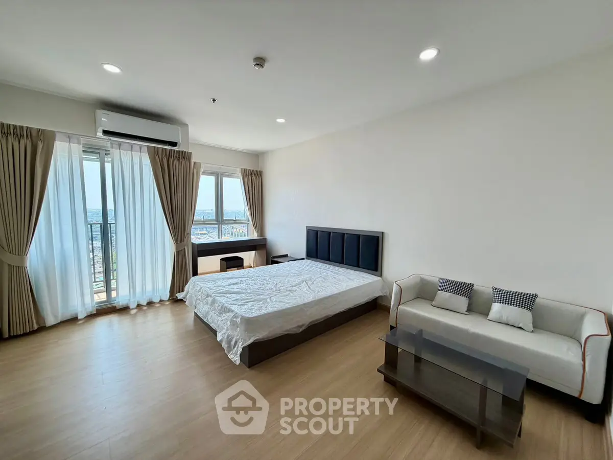 Spacious bedroom with modern furnishings and large windows offering stunning views.