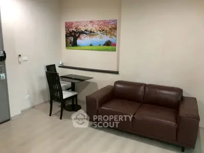 Cozy living room with modern sofa and dining area, featuring a vibrant wall art.