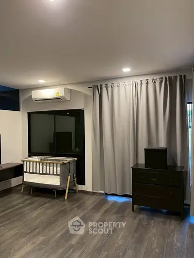 Spacious bedroom with modern flooring and natural light