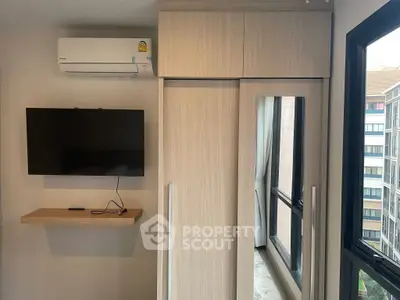 Modern bedroom with wall-mounted TV and large window view