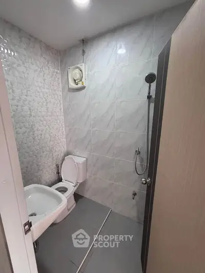 Modern bathroom with sleek design and efficient layout, featuring a shower and toilet.