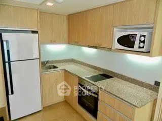 Modern kitchen with granite countertops, built-in oven, and microwave in a compact layout.