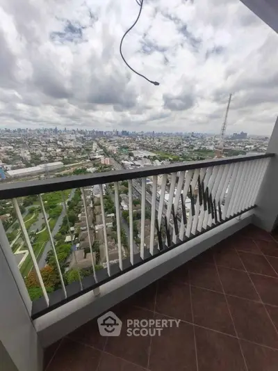 Stunning balcony view overlooking cityscape with expansive skyline and cloudy sky.