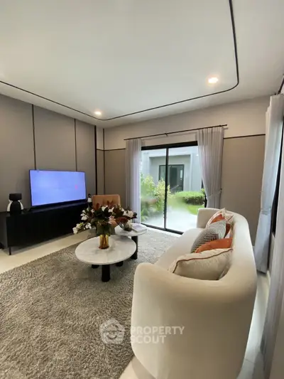 Elegant living room with modern decor and large window overlooking garden