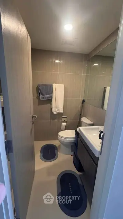Modern bathroom with sleek fixtures and neutral tones, featuring a spacious vanity and contemporary design.