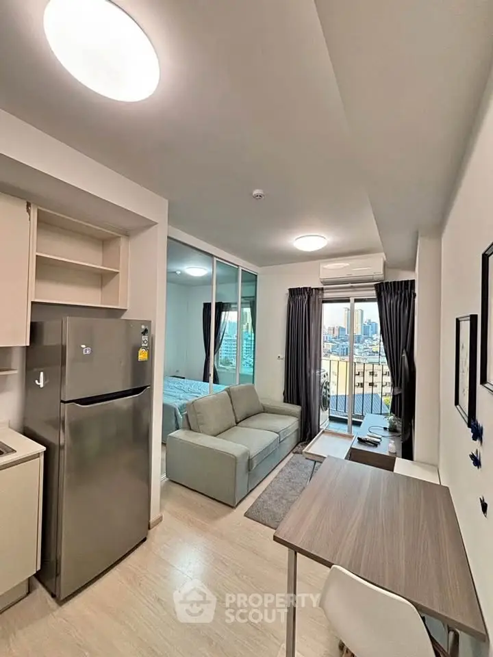 Modern apartment interior with open layout, featuring a cozy living area, compact kitchen, and city view balcony.