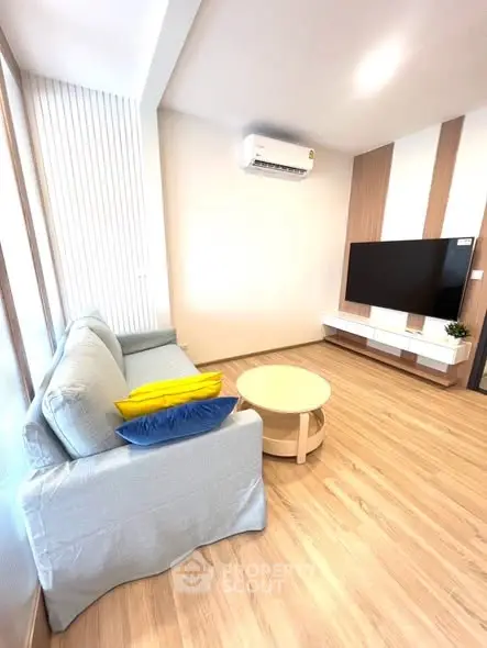 Modern living room with sleek design, featuring a cozy sofa and wall-mounted TV.