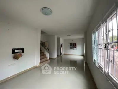 Spacious interior hallway with staircase and large windows in modern home